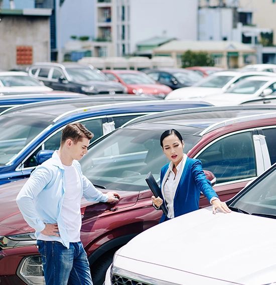 Female dealership manager helping customer to choose a car to lease