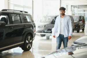 Man walking through a new car showroom looking to compare car loans